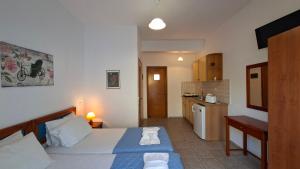 a small bedroom with a bed and a kitchen at Ninareti Studios in Agia Paraskevi