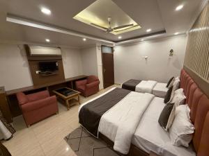 a hotel room with a bed and a living room at Hotel Valentines in Prayagraj