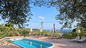 a swimming pool with chairs and umbrellas on a patio at Ninareti Studios in Agia Paraskevi +16 photos