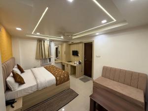 a bedroom with a bed and a bench in a room at Hotel Valentines in Prayagraj
