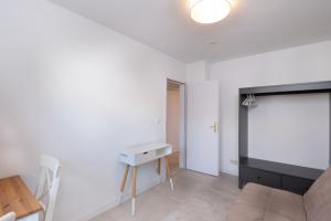a white living room with a table and a tv at Schöne moderne 2-Zimmerwohnung in Göppingen