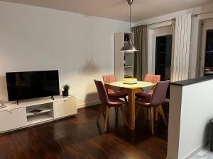 a living room with a table and chairs and a television at Ferienwohnung Brönnleins in Koblenz