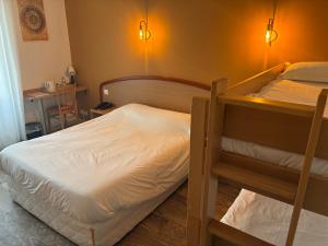 a bedroom with two bunk beds and a table at Logis Hôtel du Commerce in Volvic +35 photos