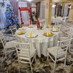 a white table with chairs and a christmas tree at Hotel Casa Traiana in Alba Iulia