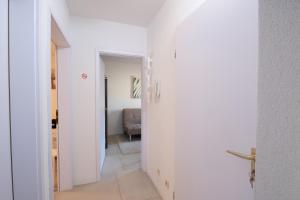 a hallway with white walls and a room with a couch at Schöne moderne 2-Zimmerwohnung in Göppingen