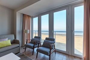 a living room with a couch and chairs and the ocean at Lecomte - The Shoreline Collection 6 in Ostend