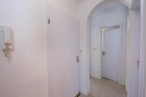 a hallway with white walls and a phone on a wall at Schöne moderne 2-Zimmerwohnung in Göppingen