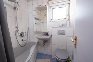 a white bathroom with a toilet and a sink at Schöne moderne 2-Zimmerwohnung in Göppingen