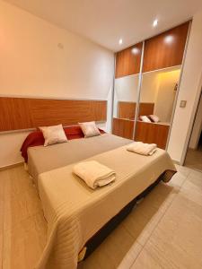 a bedroom with a large bed with towels on it at Jardines del Liceo in Comodoro Rivadavia