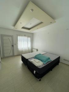 a bedroom with a bed in a white room at Jardines del Liceo in Comodoro Rivadavia +17 photos