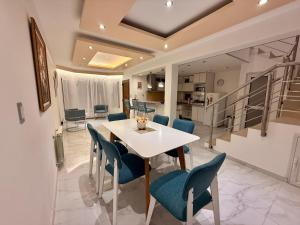 a dining room with a white table and blue chairs at Jardines del Liceo in Comodoro Rivadavia