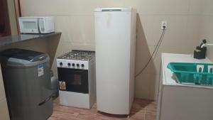 a small kitchen with a stove and a microwave at Condominio Nina2 in Icapuí