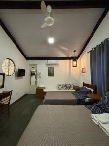 a living room with several beds and a ceiling fan at Recanto das Águas Claras in São José do Rio Prêto