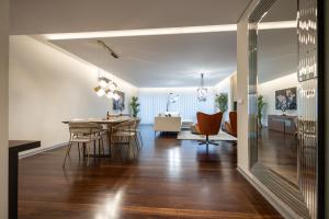 a dining room and living room with a dining table and chairs at Funchal Next Corner Plaza in Funchal