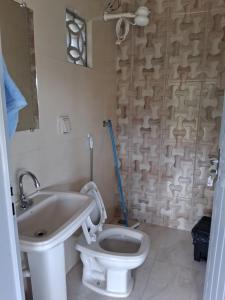 a bathroom with a toilet and a sink at CANTINHO DA ROSA ac - RIO PRIVATIVO in Manhã