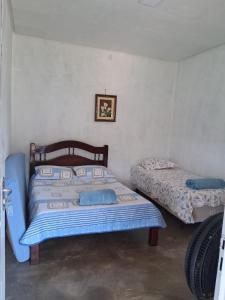 a bedroom with two beds in a room at CANTINHO DA ROSA ac - RIO PRIVATIVO in Manhã