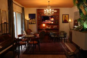a restaurant with tables and chairs and a piano at SMALL Boutique & Garden in Tirana