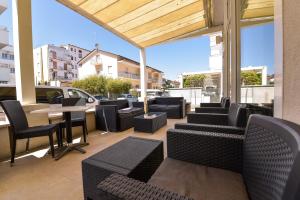 a patio with black chairs and a table and tables and chairs at Nuovo Hotel Diamante in Cesenatico