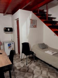 a room with a bed and a staircase and chairs at Alojamiento - Apart Hotel Libres - Hospedaje in Paso de los Libres