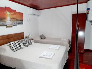 two beds in a room with white walls at Alojamiento - Apart Hotel Libres - Hospedaje in Paso de los Libres