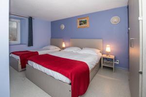 Domaine du Haut des Bluches في لابريس: سريرين في غرفة نوم بجدران زرقاء