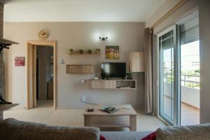 a living room with a couch and a tv at Stergios top view residence with jacuzzi in Kolymbia