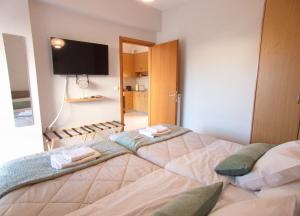 a bedroom with a large bed with a tv on the wall at Peris #2 - Souda in Souda