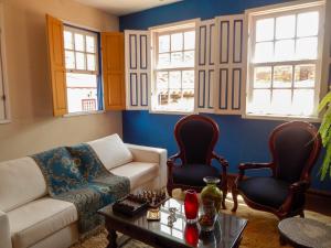 a living room with a couch and two chairs and a table at Casa da Kau in Ouro Preto