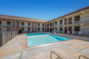 a swimming pool in the courtyard of a apartment building at Red Roof Inn College Station in College Station