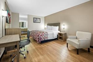 a hotel room with a bed and a desk and chair at Red Roof Inn College Station in College Station +22 photos
