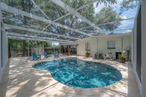 an indoor swimming pool with a pergola on a patio at Spacious Boho Retreat Heated Pool-HotTub-Huge Yard in Tampa