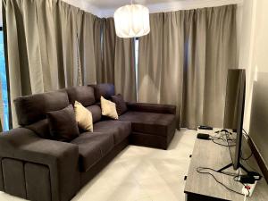 a living room with a brown couch and a table at Pure Vilamoura 2 bedrooms with pool in Quarteira