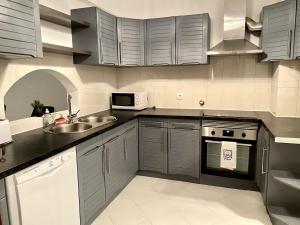 a kitchen with a sink and a microwave at Pure Vilamoura 2 bedrooms with pool in Quarteira
