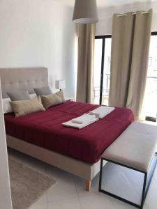 a bedroom with a large bed with a red blanket at Pure Vilamoura 2 bedrooms with pool in Quarteira +38 photos