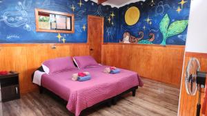 a bedroom with a pink bed with two teddy bears on it at HARE O HAUPIANO in Hanga Roa
