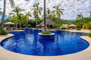 a large pool with palm trees in a resort at Alamar Vallarta in Cruz de Huanacaxtle