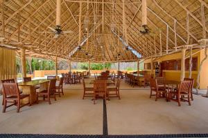 a restaurant with tables and chairs and a large ceiling at Alamar Vallarta in Cruz de Huanacaxtle