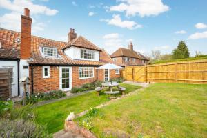 a backyard with a table and an umbrella at 4 Bed in Westleton oc-holc in Westleton