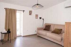 a white living room with a couch and a lamp at SOUS LES PLATANES in Velaux