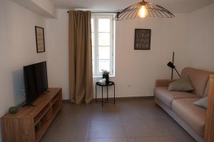 a living room with a couch and a television at SOUS LES PLATANES in Velaux