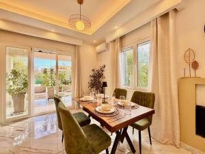 a dining room with a table and green chairs at Villa Sunlight Sidari with private pool by DadoVillas in Sidari