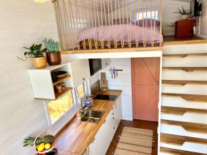 a tiny house with a kitchen and a staircase at Tiny House Gänseblümchen in Kirchanschöring