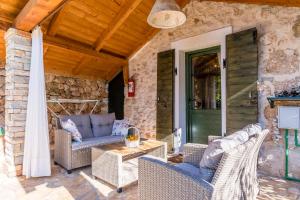 a patio with wicker furniture and a green door at House Dobrila in Igrane