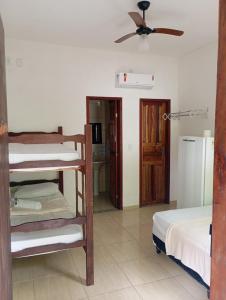 a room with two bunk beds and a ceiling fan at Pousada Mestre Lua - Itaúnas in Conceição da Barra
