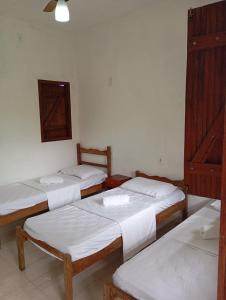 a group of four beds in a room at Pousada Mestre Lua - Itaúnas in Conceição da Barra