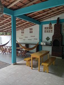 a patio with a table and benches and a fireplace at Pousada Mestre Lua - Itaúnas in Conceição da Barra