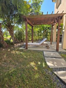 a wooden pergola with a bench in a yard at Atlas in Homestead