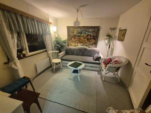 a living room with a couch and two chairs at Sjarmerende 50-tallshus med utsikt og ro in Olderdalen