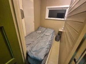 a small bed in a small room with a window at Sjarmerende 50-tallshus med utsikt og ro in Olderdalen