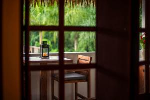 a table with a candle and a chair in front of a window at Vayu Retreat Villas in Coronado